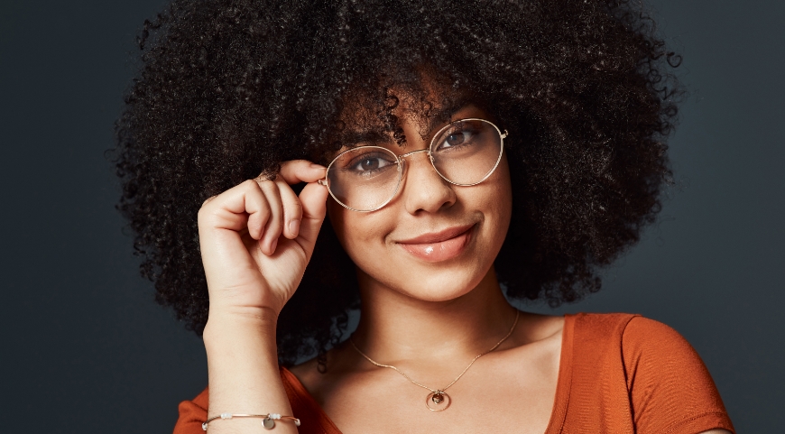 woman with curly hear wearing circular glasses
