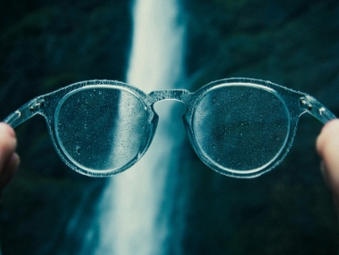 transparent eyewear frames in front of waterfall