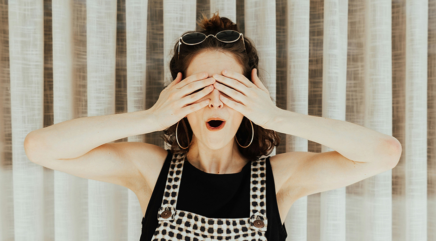 a woman laying down and holding her eyes closed