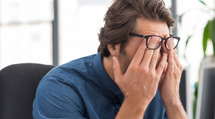 man rubbing tired eyes