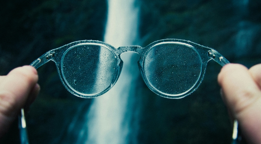 transparent eyewear frames in front of waterfall